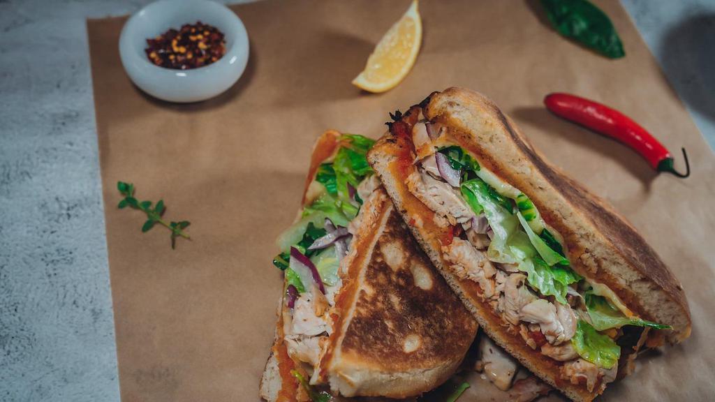 Grilled Chicken Paradiso Sandwich · House-made bread, grilled chicken, mozzarella, sun-dried tomatoes, pesto, red onions, lettuce, balsamic aioli. No asiago.