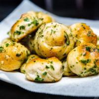 Garlic Knots (6 Per Order) · Golden baked dough knots marinated with fresh garlic, olive oil, and seasonings.
