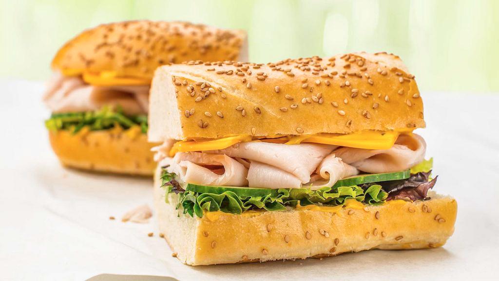 Traditional Turkey · Thinly sliced turkey with provolone cheese, organic green leaf lettuce, cucumbers, and organic yellow mustard on our traditional sesame seed sub roll..