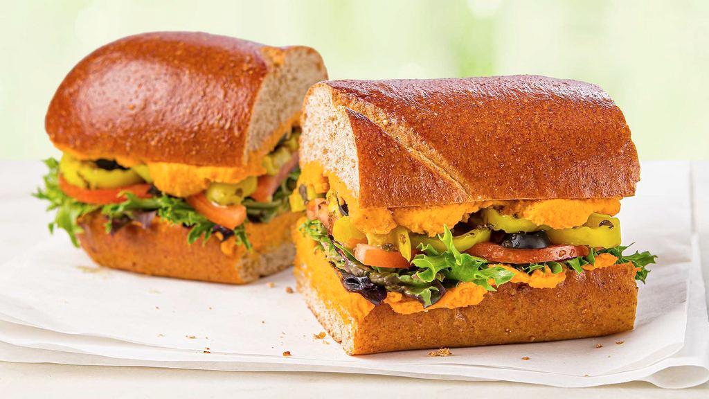 Roasted Red Pepper Hummus Sub · Our creamy Roasted Red Pepper Hummus, fresh field greens, tomatoes, banana peppers, black olives, and our signature oil on a wheat sub roll.