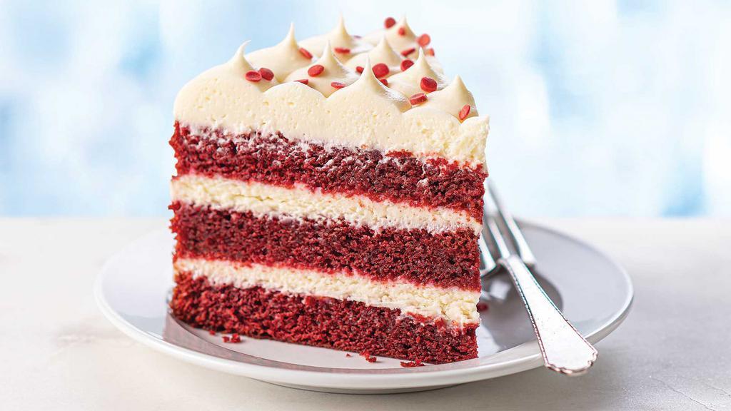 Red Velvet Cake Slice · Three layers of moist, tender red velvet cake filled and topped with cream cheese icing and garnished with sugar sequins.