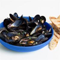 Mussels · Steamed mussels with a side of toast and white or red sauce.