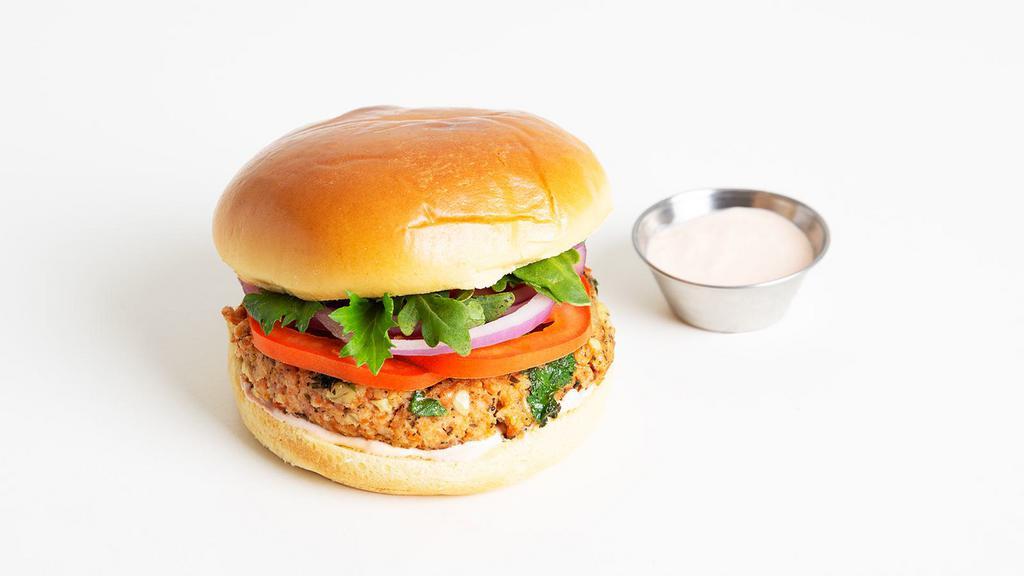 Salmon Burger · Salmon burger with tomato, red onion, and aioli on a brioche bun.