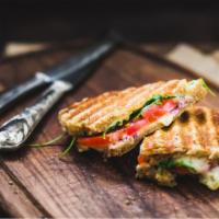 The Italiano Panini · Grilled Panini Sandwich made with Grilled chicken, roasted peppers, fresh mozzarella, and pe...