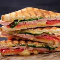 Turkey Club Panini · Grilled Panini Sandwich made with Turkey, bacon, lettuce, tomatoes, and house dressing.