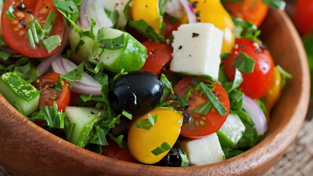 Greek Salad · Freshly prepared salad topped with Romaine lettuce, feta cheese, stuffed grape leaves, tomatoes, red onions, kalamata olives, cucumbers, and bells peppers.