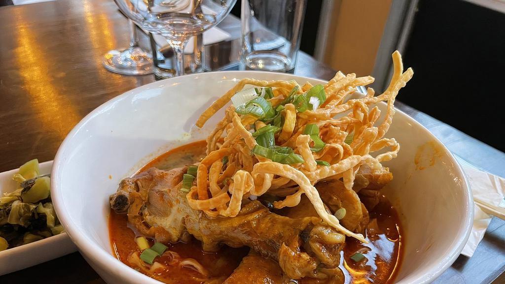 Khao Soi Chiang Mai · Mild spicy. Chicken drum sticks. Steamed egg noodles in curry sauce full of the citrus tang of kaffir lime leaf and the fragrance of rhizome and lemongrass topped with, red onion, lime wedged, house pickled mustard and topped with crispy egg noodle.
