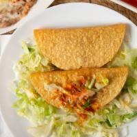 Tacos De La Casa · Crispy corn tortilla shell with choice of shredded chicken or ground beef. Topped with lettu...