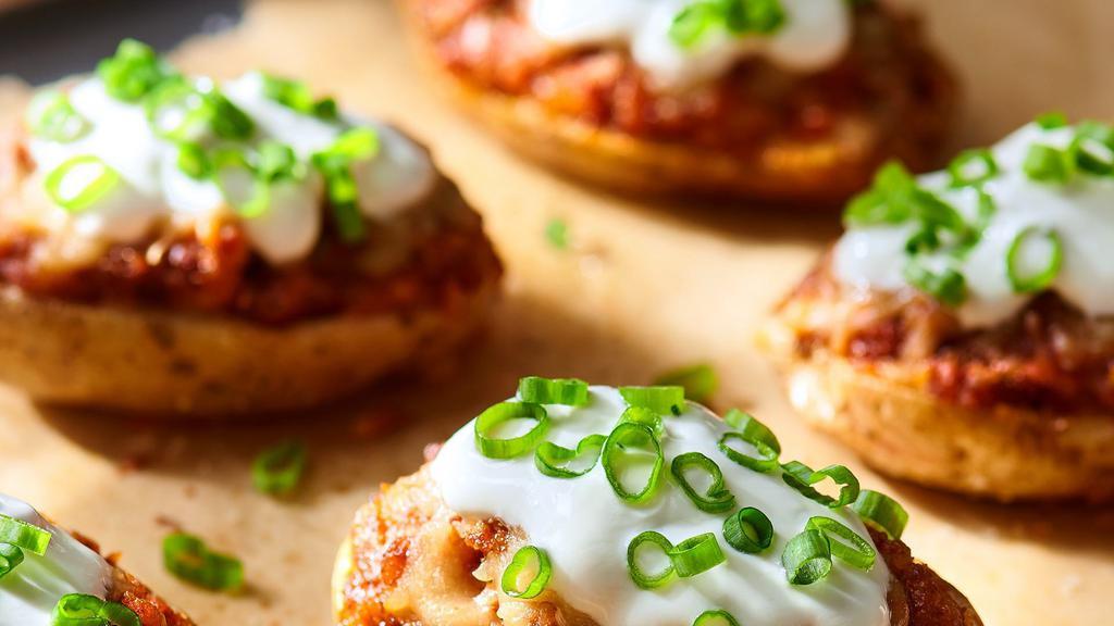 Mexican Potato Skins · Potato skins filled with chili and covered with melted cheddar and jalapeno served with sour cream, garnished with cilantro.