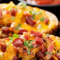 Pot Skins · Topped with melted cheddar, chopped bacon & onions. Served with sour cream, Garnished with C...