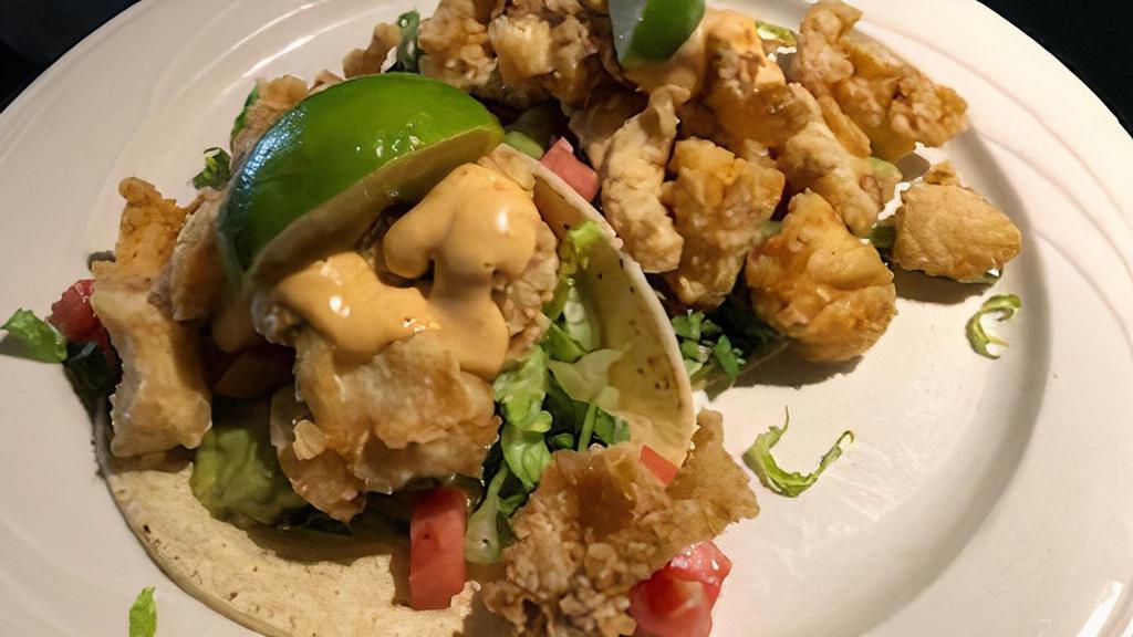 Fish Tacos With Avocado Lime Salsa And Chipotle Drizzle · Seasoned fried cod fillet with shredded lettuce, cilantro-avocado salsa in a warm soft corn tortilla.