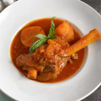 Lamb Shank (Lunch) · Shank of domestic lamb simmered with herbs and garlic in tomato sauce. Served with green rice.