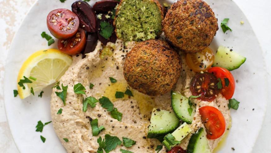 Falafel Entree · Vegetarian. Chunks of falafel balls served over a bed of hummus with rice and vegetables on the side.
