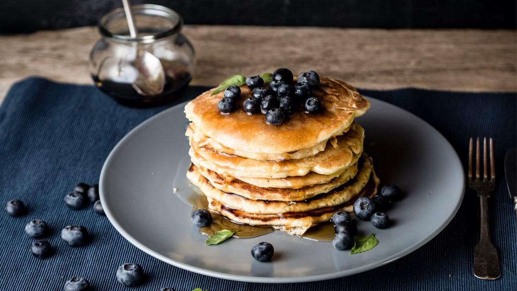 Blueberry Buttermilk Pancakes (3 Pcs) · 3 perfectly fluffy blueberry pancakes, served  with a side of butter and syrup.