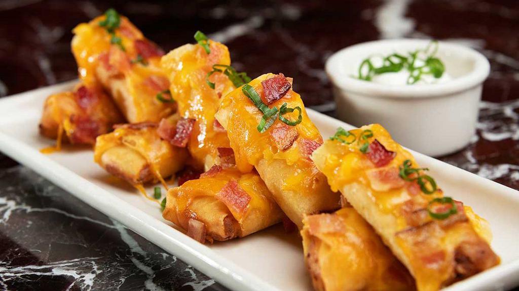 Double Stuffed Potato Spring Rolls® · Creamy Mashed Potatoes with a Touch of Green Onion, Rolled in Crispy Asian Wrappers Topped with Melted Cheddar, Applewood Smoked Bacon and Green Onion. Served with Sour Cream