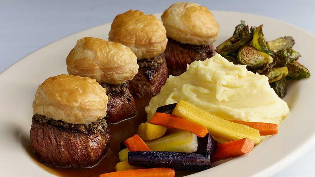 Cafe Beef Wellington · Filet Mignon Steak Medallions Covered with Crimini Mushrooms and Topped with Warm Puff Pastry. Served with Madeira Wine Sauce, Mashed Potatoes and Vegetables