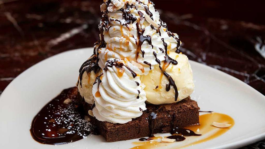 Warm Brownie Sundae · Our Housemade Brownie Topped with Vanilla Ice Cream, Whipped Cream, Toasted Almonds, Chocolate Fudge and Caramel Sauce. Served with Jack Daniels Crème Anglaise