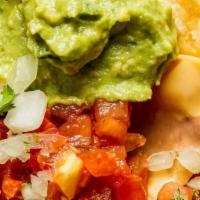 Nachos · Corn tortilla chips topped with refried beans, cheese sauce, pico de gallo, sour cream, guac...