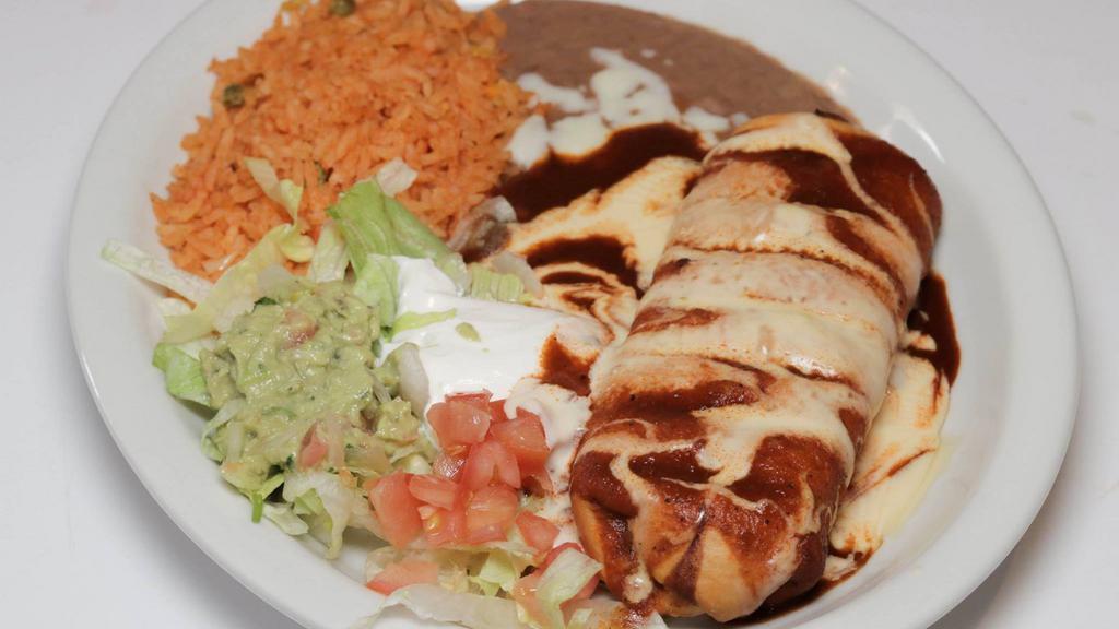 Chimichangas · Two flour tortillas, soft, or fried, filled with ground beef or chicken or pork, beans, lettuce, tomatoes, sour cream, nacho cheese sauce and guacamole.