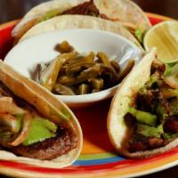 Tacos Carne Asada · Tortillas stuffed with slices of steak.