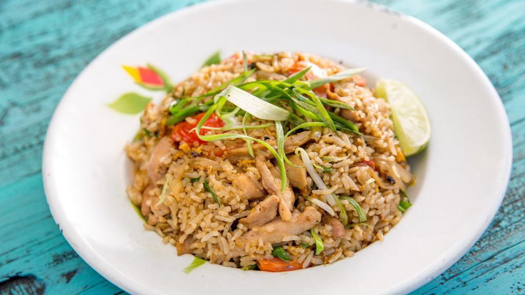 Fried Rice · Stir-fried jasmine rice, egg, meat with onions, scallions, and tomatoes in a brown sauce.