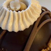 Peanut Butter Mousse Dome · A cookie base filled with peanut butter mousse, coated in chocolate and topped with peanut b...
