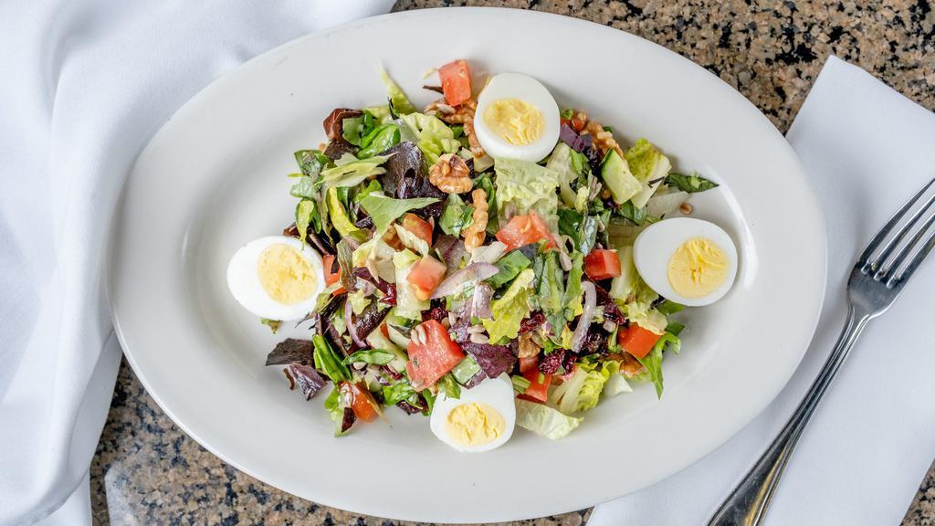 Healthy Chopped Salad · Mixed greens, sunflower seeds, dried cranberries, wheat berries, hard-boiled egg, walnuts, onions, tomatoes and cucumbers with a lemon vinaigrette.