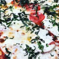 Caprese Pizza · Sliced tomatoes, fresh mozzarella cheese, fresh herbs, and fresh basil.