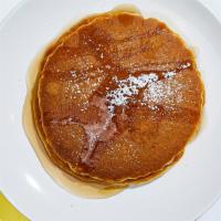 Vegan Pancakes · Two buckwheat pancakes with maple syrup and powdered sugar.