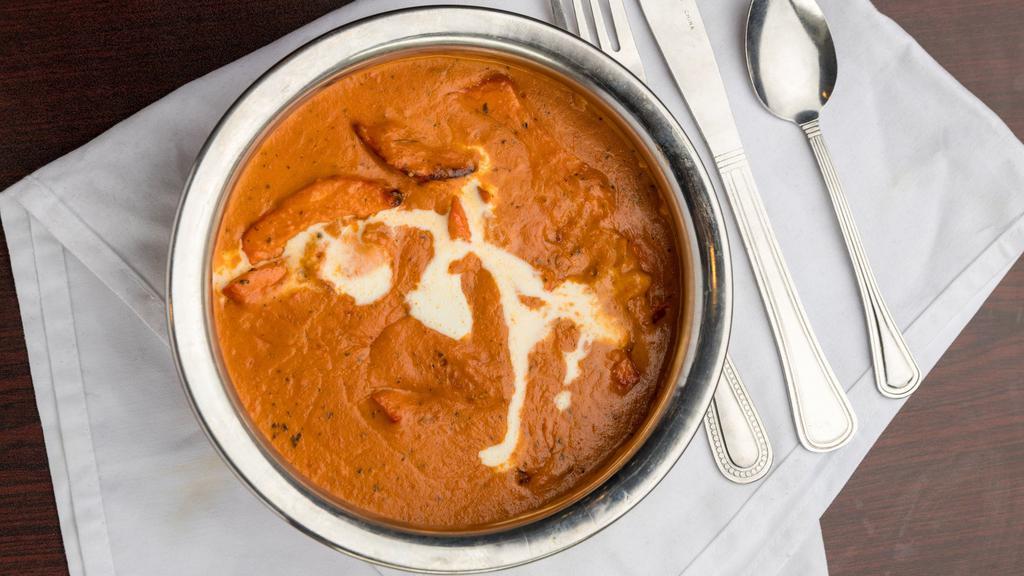 Butter Chicken · A timeless favorite. Chunks of chicken cooked in a smooth butter & tomato based gravy, flavored with dried fenugreek leaves & aromatic spices