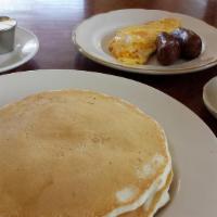 Three By Three · Three pancakes or three slices French toast and three eggs with melted cheese and bacon, sau...