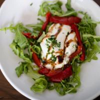 Burrata · Burrata served over baby spinach and chopped red peppers.
