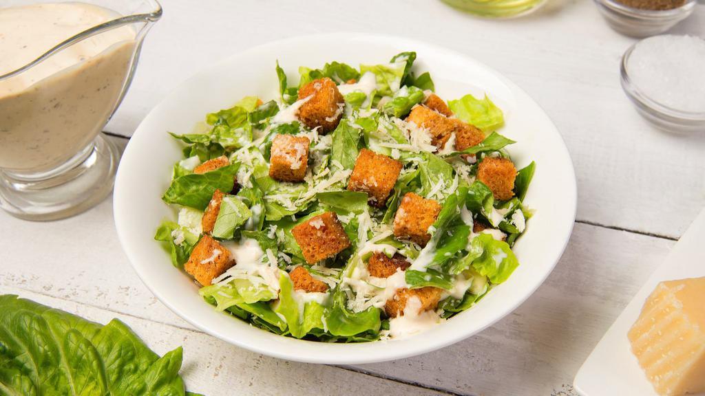 Caesar Salad · Fresh greens topped with romano cheese and herb croutons with a side of caesar dressing.