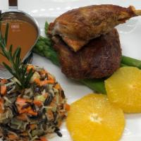 Canard A L'Orange · Roasted half duck, vegetable wild rice, asparagus, orange sauce.