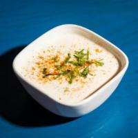 Raita · Whipped yogurt with cucumbers, potatoes and carrots lightly spiced with black peppers.