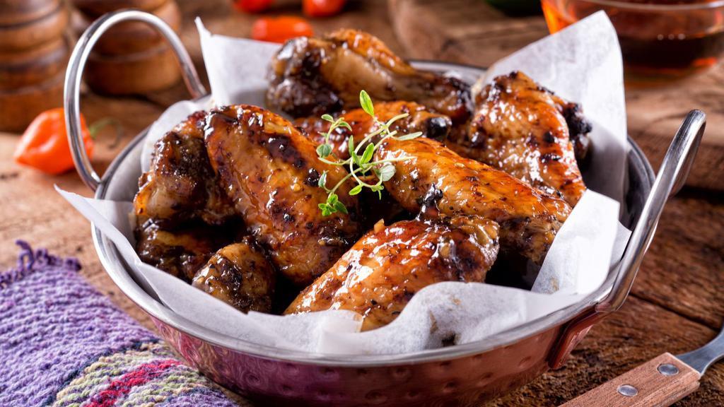 Mango Habanero Wings · Golden, crispy, deep-fried wings, glazed with the tropical heat of mango and habanero sauce. Add on a dipping sauce and side!