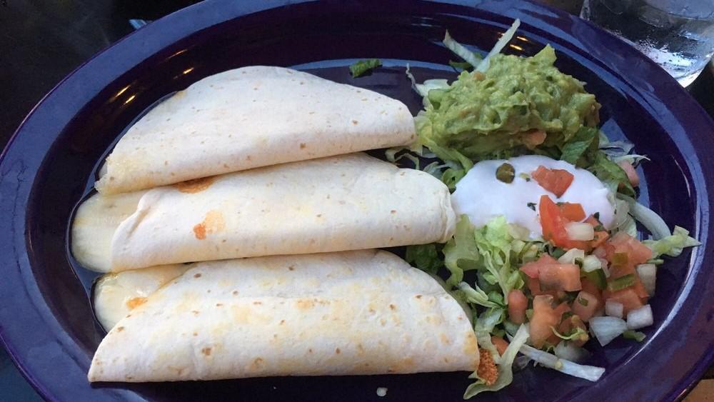 Fish Tacos · Three soft corn tortillas filled with Yucatan-style fried catch of the day and cabbage with a Mexican cream and cilantro dip.