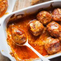 Polpette Al Forno · Housemade meatballs baked in a tomato ragout topped with a blend of cheese served with garli...