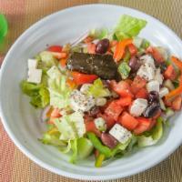 Traditional Greek Salad · Romaine, tomato, cucumber, onions, peppers, olives, feta cheese, and stuffed grape leaves wi...