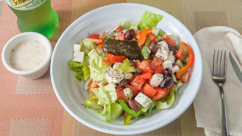 Traditional Greek Salad · Romaine, tomato, cucumber, onions, peppers, olives, feta cheese, and stuffed grape leaves with house dressing.
