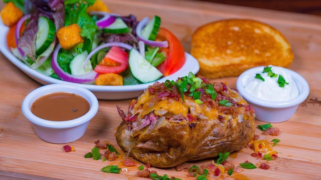 Stacked Baked Potato & Salad · Loaded baked potato topped with house smoked, hand pulled pork or Texas style beef brisket, cheddar jack cheese, bacon, sour cream, green onions, served with garlic bread, and choice of Garden Greens or Caesar side salad.