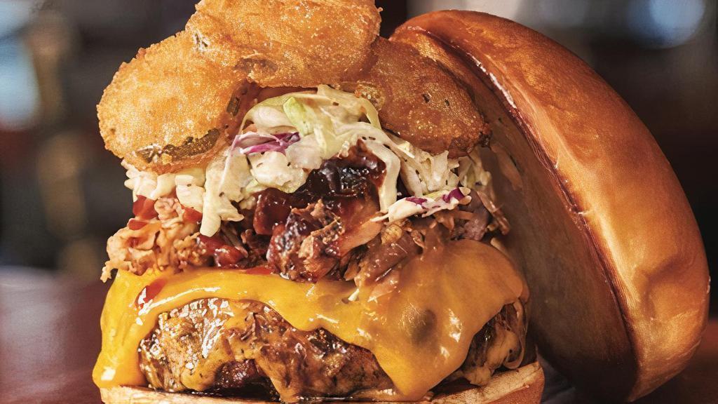 Signature Bbq Burger · House-smoked pulled pork, cheddar, coleslaw, fried pickles, Memphis Seasoning, and KC BBQ Sauce. Served with your choice of 1 side.