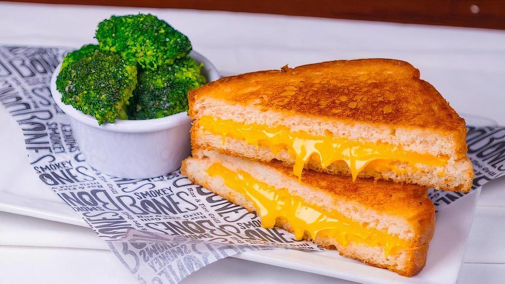 Kid'S Grilled Cheese · Traditional grilled cheese on white bread and American Cheese. Served with your choice of 1 regular side and a beverage.