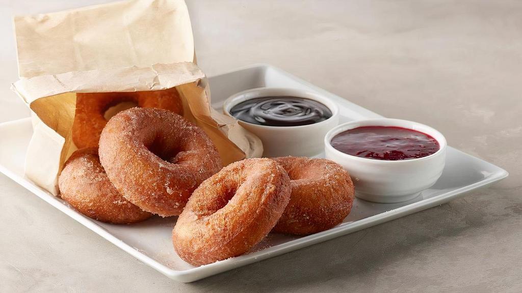 Hot Bag O' Donuts · A bag of fresh, fluffy, round, cinnamon-sugary donuts, chocolate and raspberry dipping sauces.