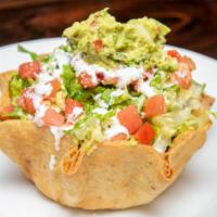 Taco Salad · Crisp flour tortilla shell filled with refried beans, Spanish rice, lettuce, tomatoes, chees...