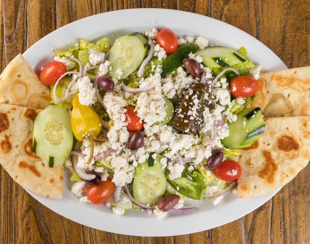 Greek Salad · romaine, tomatoes, cucumbers, red onions, peppers, dolma, kalamata olives and feta cheese served with our house evoo vinaigrette.