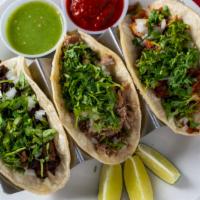 Mexican Chorizo Tacos · Three corn tortillas with onions, cilantro, limes and salsa on the side.