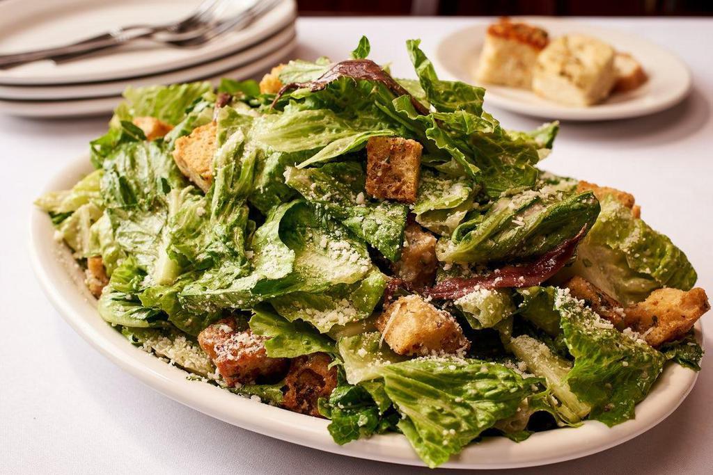 Caesar Salad · Romaine Lettuce, Parmesan Romano Cheese, Homemade Garlic Croutons- Served with House Made Caesar Dressing on the Side. (Dressing will always contain Anchovy Paste) - Feeds 2-4