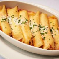 Manicotti  · Thin Italian Egg Crepes Stuffed with a Mixture of Four Cheeses - Baked Over a Layer of Our S...