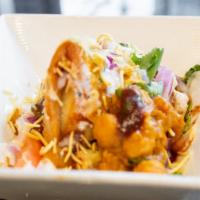 Samosa Chaat · deconstructed samosa topped with chickpeas, chopped onion & tomato, garnished with spiced yo...